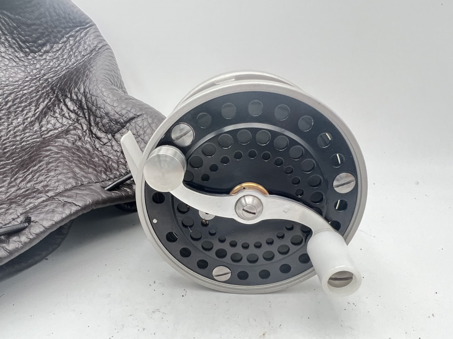Lachsfliegenrolle, Gentle Craft Salmon 1, baugleich mit einer Bogdan 150, Linkshand, Klasse 8/9, Übersetzung 2:1, Backenbremse, Gewicht 345 Gramm, beide Seitenteile gelocht, Rollendurchmesser 88mm, Rollenbreite 60mm, aus hochwertigem Aluminium, Oberflächen Glaskugelgestrahlt, aufwendig eloxiert und Glaskugel verdichtet, dadurch erhält die Rolle eine sehr kratzfeste Oberfläche, Gehäuse, Spule und Rollenfuß hellgrau, Seitenteile schwarz, mit handgefertigtem Lederbeutel, Made in Bavaria
