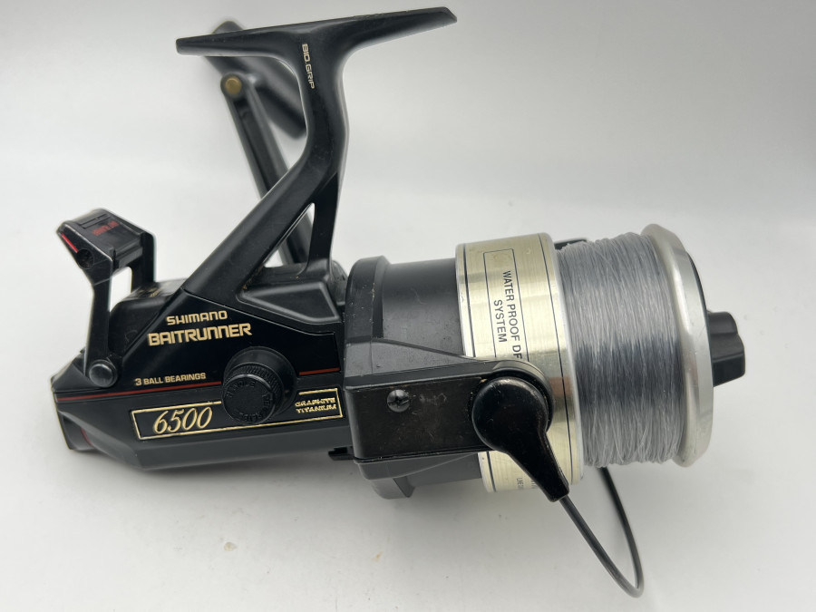 Stationärrolle Shimano Baitrunner 6500, 3 Ball Bearings, Graphite/Titanium, Linkshand, mit Schnur Gebrauchsspuren