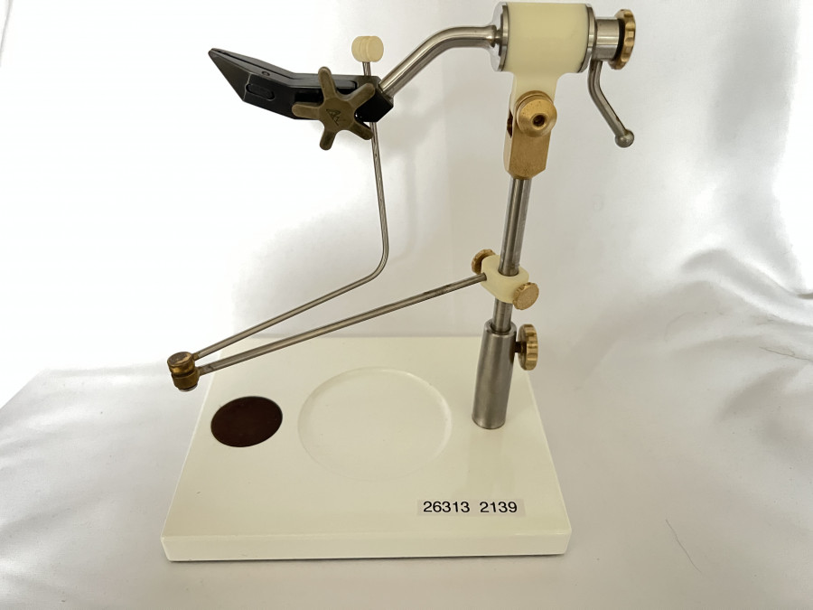 Fliegenbindestock, Law Vice, der funktionellste, eleganteste und schönste Fliegenbindestock aller Zeiten, sehr seltene Ausführung für Linkshand, die Backen sind aus CR12 Werkzeugstahl gefertigt und Rockwell RC58 gehärtet. Sie nehmen Haken von Grösse 32 bis 10/0 auf und lassen sich über ein Messingsternrad leicht und präzise öffnen und schließen. Der Schraubstock ist in alle Richtungen verstellbar und dreht sich in einem Delrin Gehäuse auf längs und quer angeordneten Lagern. Der großzügige, stabile Sockel hat eine zentrale Schale für Haken usw, gefertigt 2005, leichte Gebrauchsspuren