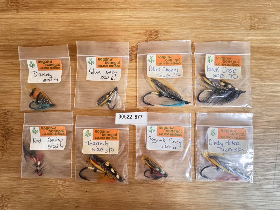 8 Lachsfliegen von Rogan of Donega,l ungefischt in der alten Original-Verpackung. (4 mal Größe 3/0 und zwar. „Black Dose“, „Torrish“, „Blue Chorm“ und „Dusty Miller“, 4 mal die kleine Größe 4 bzw. 6 und zwar: „Silver Grey“, „Dandy“, „Red Shrimp“ und „Rogan´s Fancy“).
