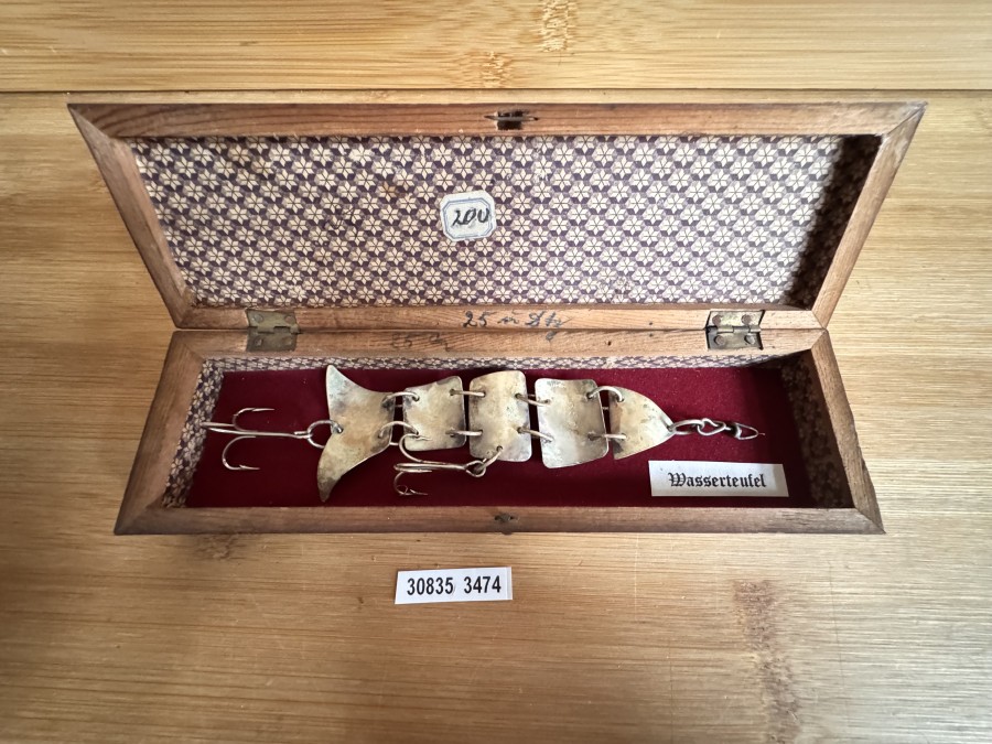Gliederfisch „Wasserteufel“-Nachbildung – wie im DAM Katalog Fritz Ziegenspeck 1920 – wer keinen 4stelligen Betrag für ein Original ausgeben will, kann sich für einen kleinen Bruchteil  seine Vitrine ergänzen. Es gibt 3 Exemplare davon. Der Köder ist mit „2505“ gepunzt. Es ist das 13 cm Modell in einem schönen Holzetui.